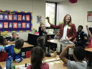 A woman standing in front of a group of children.