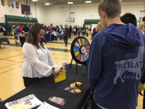 A woman is handing out prizes to people.