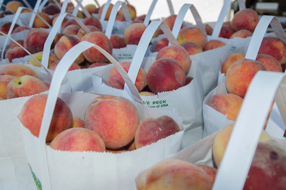 A bunch of bags filled with peaches sitting on top of each other.