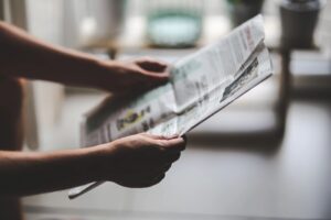 A person holding a newspaper in their hands.