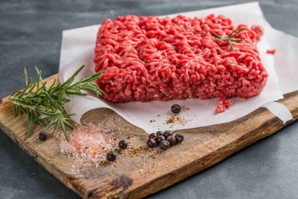 A piece of ground beef on top of a cutting board.