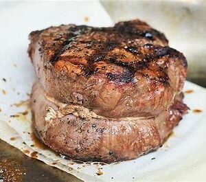 Grilled beef steak on parchment paper.