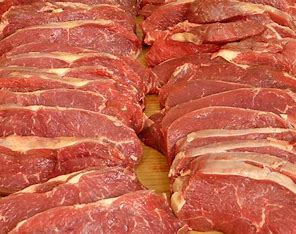 Freshly cut raw beef steaks on display.