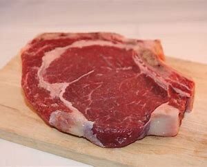 Raw beef steak on a cutting board.