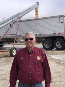 A man standing in front of a large trailer.