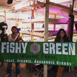 A group of people holding up a sign for fish and green.