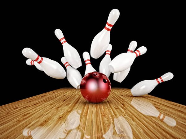 A bowling ball and ten pins on the floor.