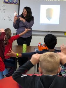 A woman teaching students how to play wii