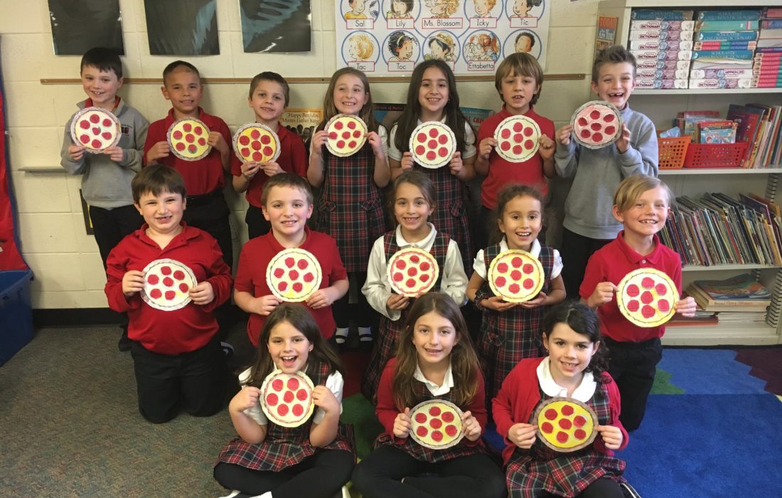 A group of children holding up pizzas in front of them.