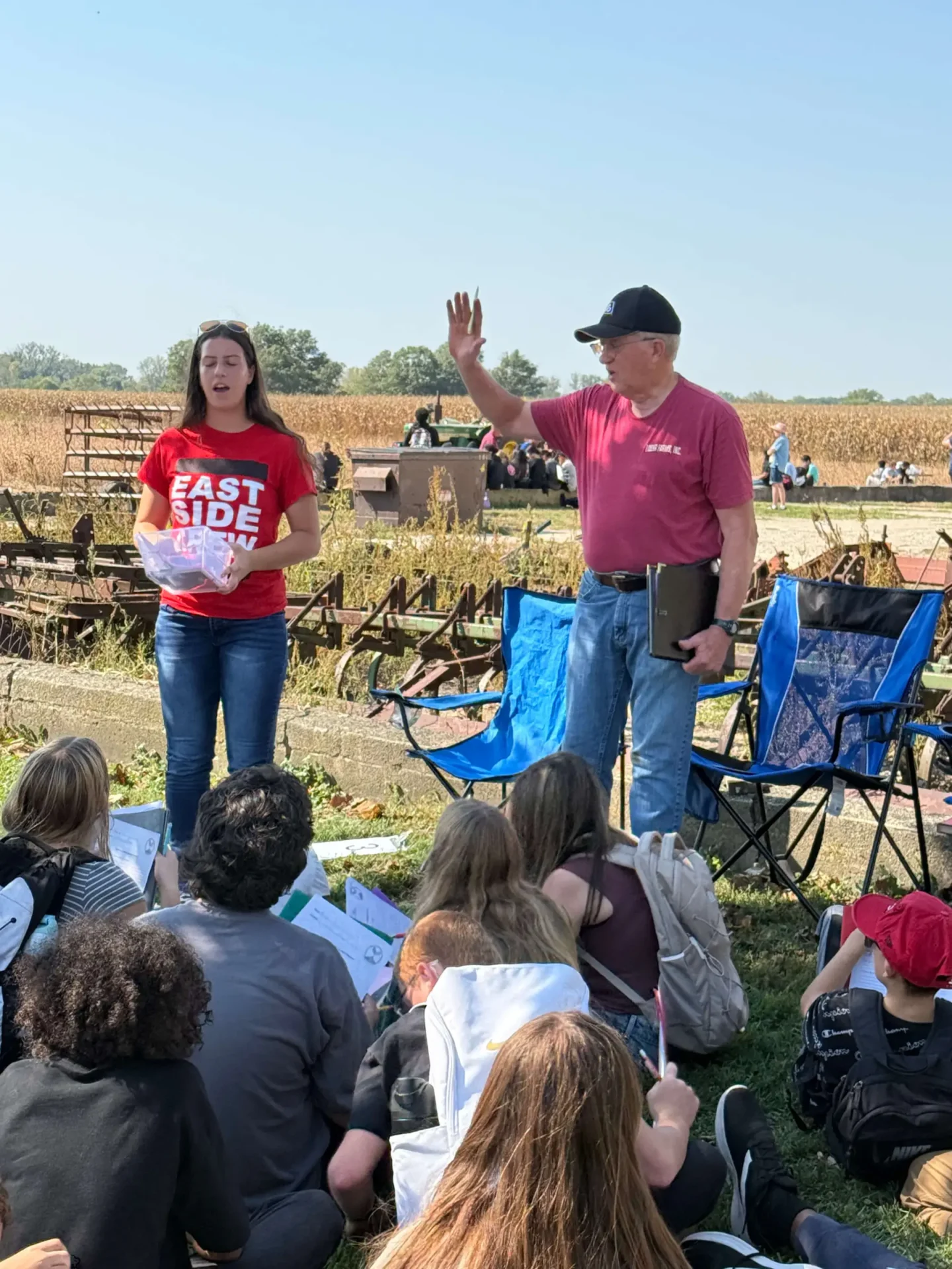 Outdoor educational session with a group seated.